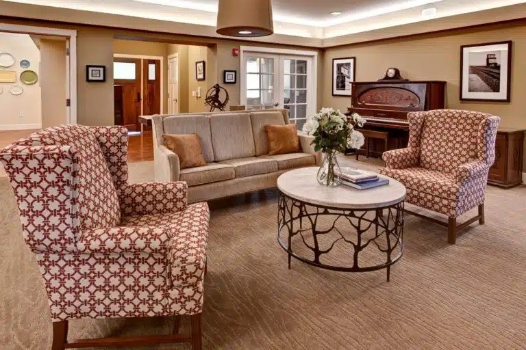 A living room with patterned chairs and a sofa  at The Piper, Kansas City, KS.